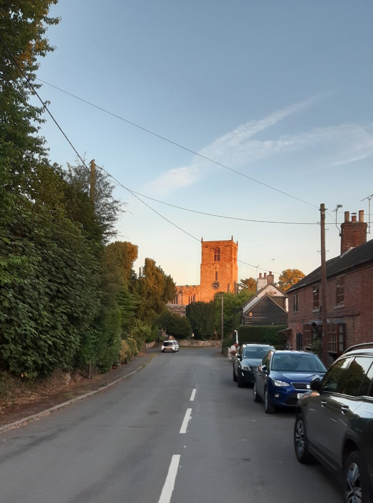 The church viewed looking south down Church Lane, late on a summer evening