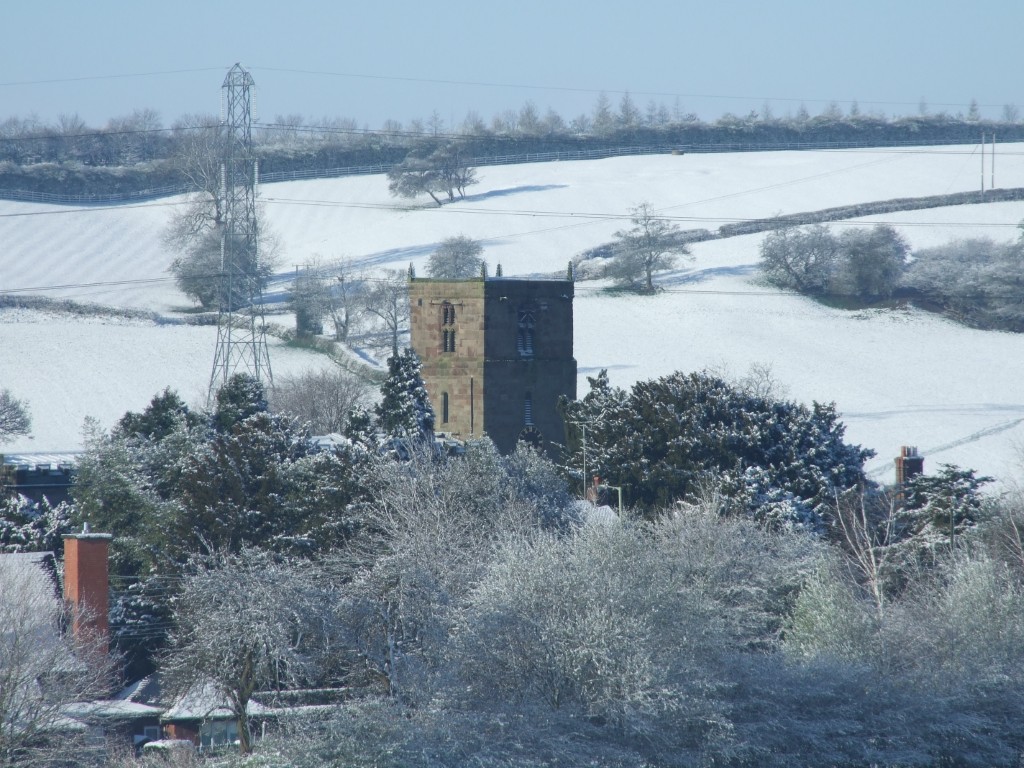 The church tower above the trees on a winters day